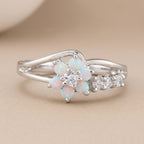 hero: A new photorealistic photograph, composed from scratch, of a piece of jewelry. The product rests on a seamless matte warm beige studio surface that smoothly transitions into a matching, softly graduated background. The atmosphere is quiet, neutral, and minimalist, with a neutral white balance. The ring is placed with its natural orientation, centered horizontally and positioned slightly below the vertical center of the frame. The complete ring is visible, occupying approximately 68% of the image widt…